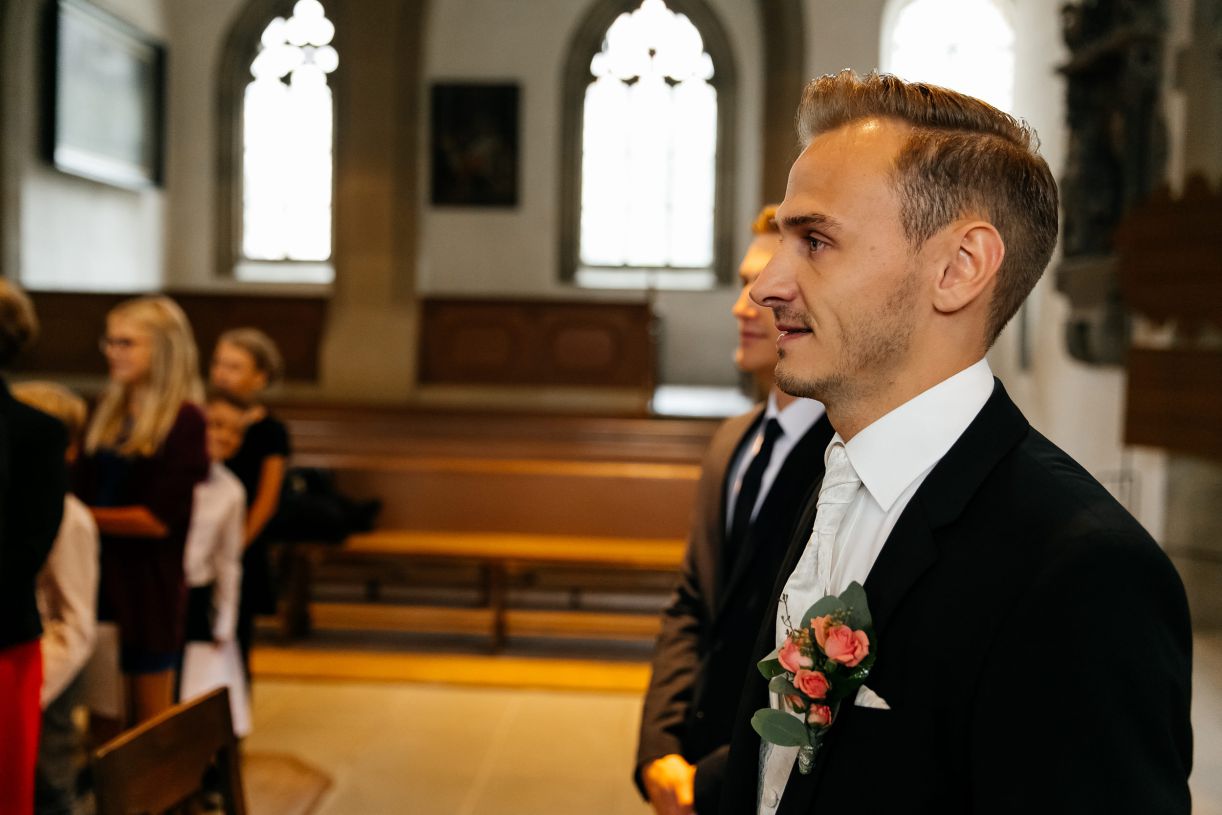 Kirchliche Trauung. Der Bräutigam wartet auf die Braut in der Kirche. Hochzeitsfotograf in Schweinfurt.
