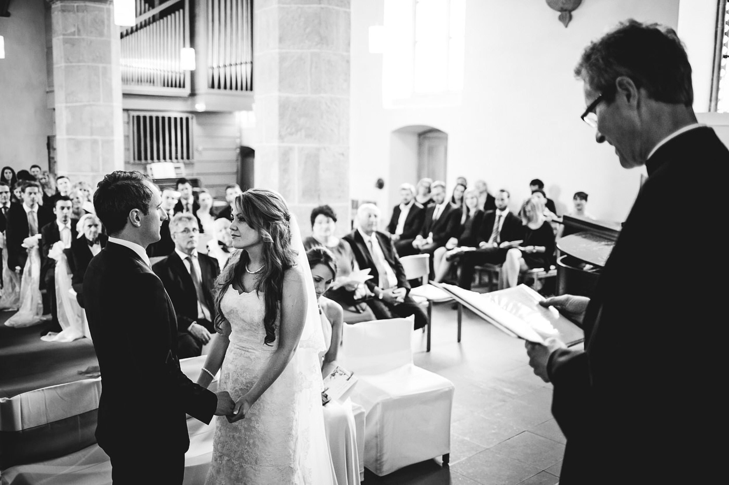 Kirchliche Trauung. Brautpaar steht vom Alter Hand in Hand.