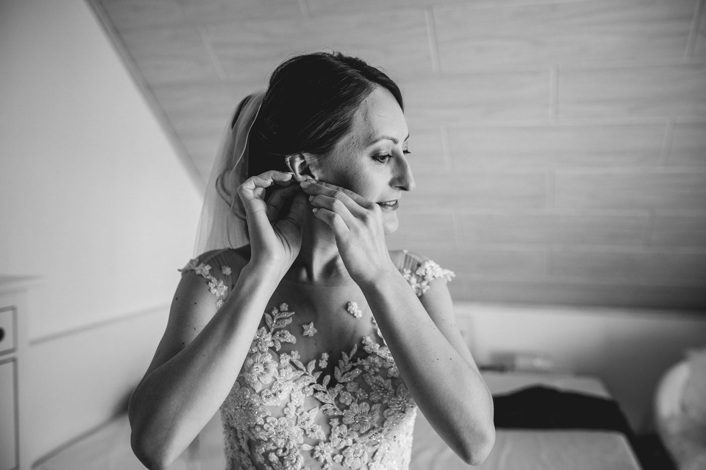Braut steckt sich die Ohrringe an, schwarz weiß. Hochzeitsfotograf in Bad Ems