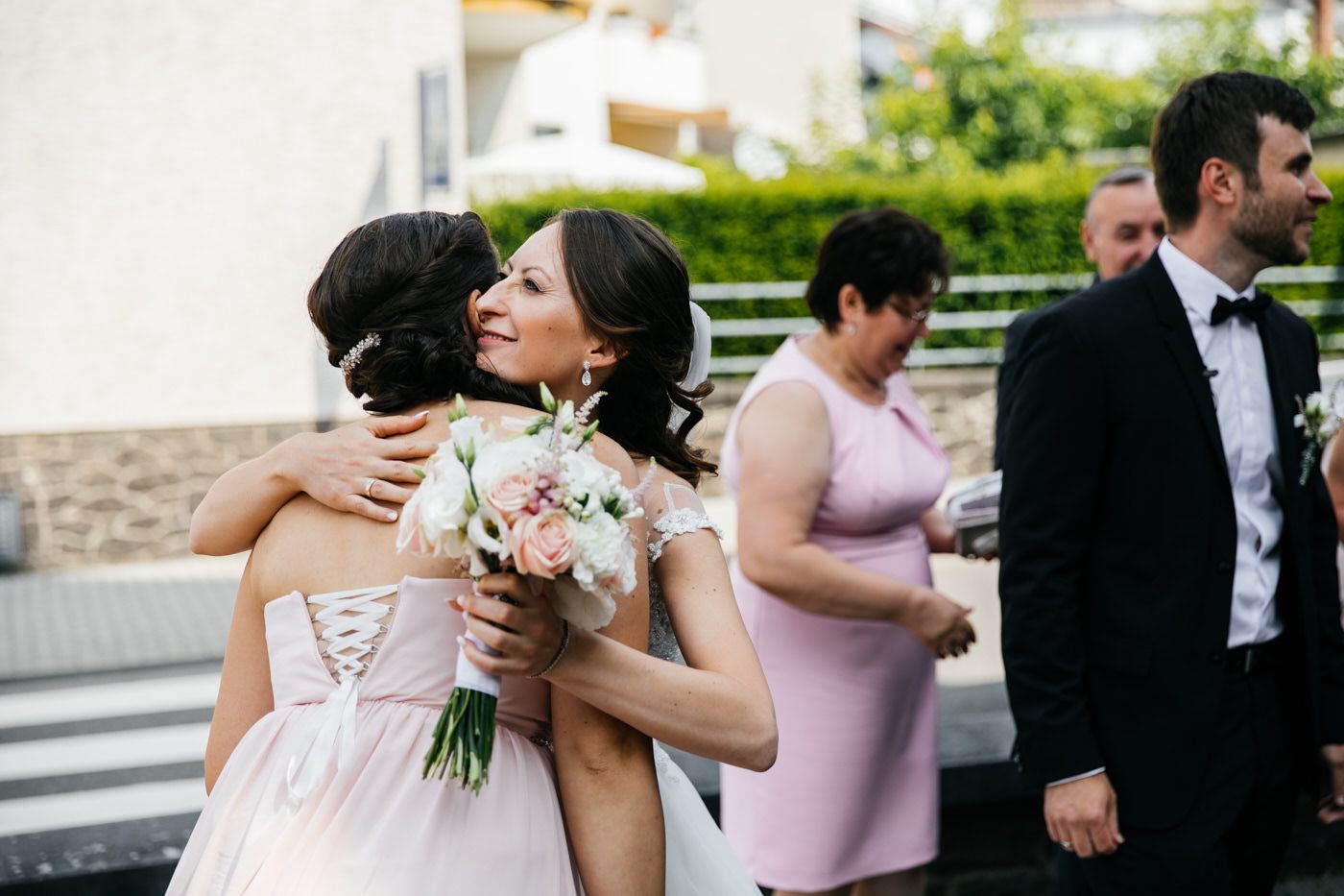 Kirchliche Trauung. Die Braut umarmt die Trauzeugin. Hochzeitsfotograf in Bad Ems.