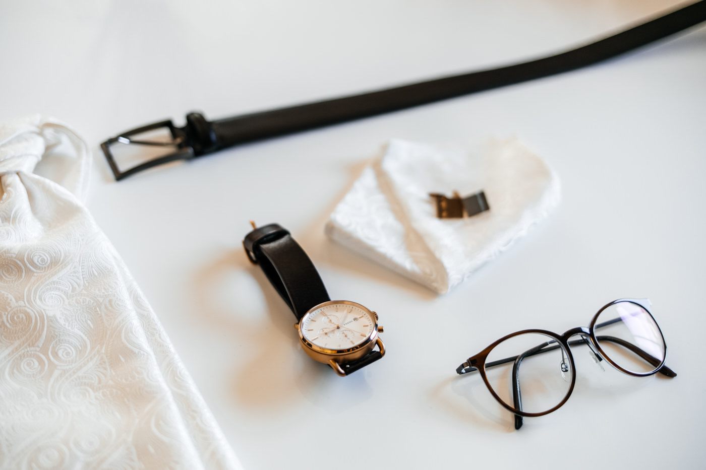 Die Sachen von Bräutigam - Brille, Uhr, Manschettenknöpfe und Gürtel. 