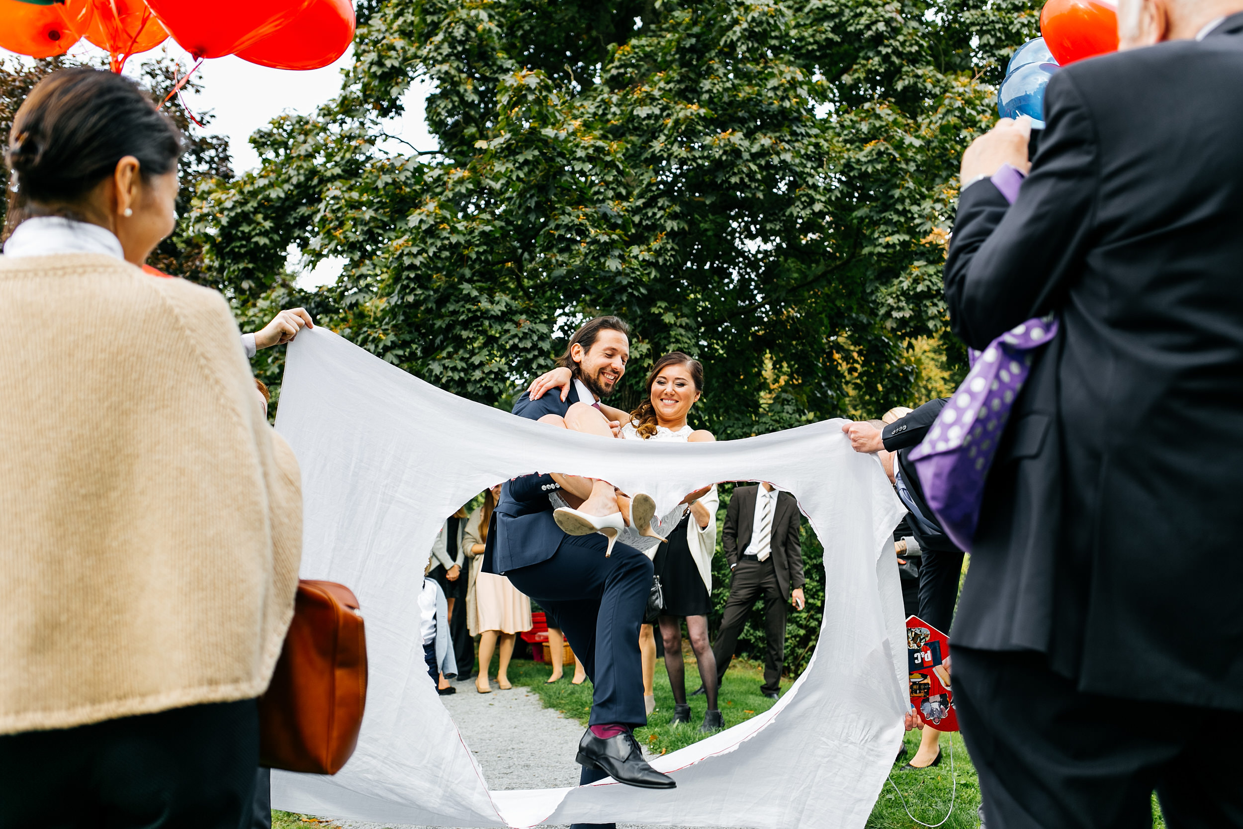 Standesamtliche Trauung auf Gut Eckendorf. Das Brautpaar steigt durch das ausgeschnittene Herz. Hochzeitsfotograf in Bielefeld.
