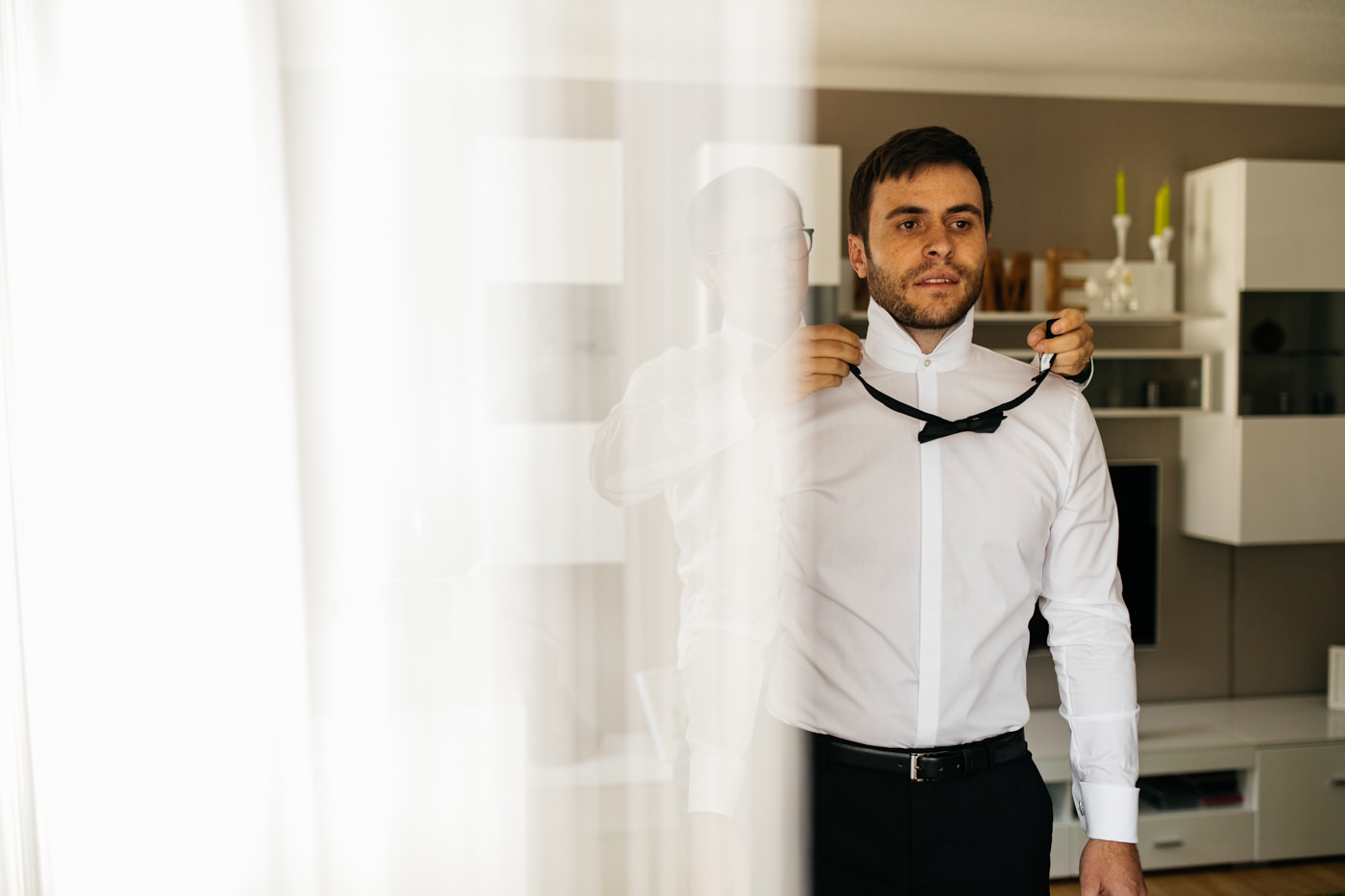 Br&auml;utigam und Trauzeuge. Der Trauzeuge hilft dem Br&auml;utigam die Fliege anzubringen. Als Hochzeitsfotograf in Bad Ems.