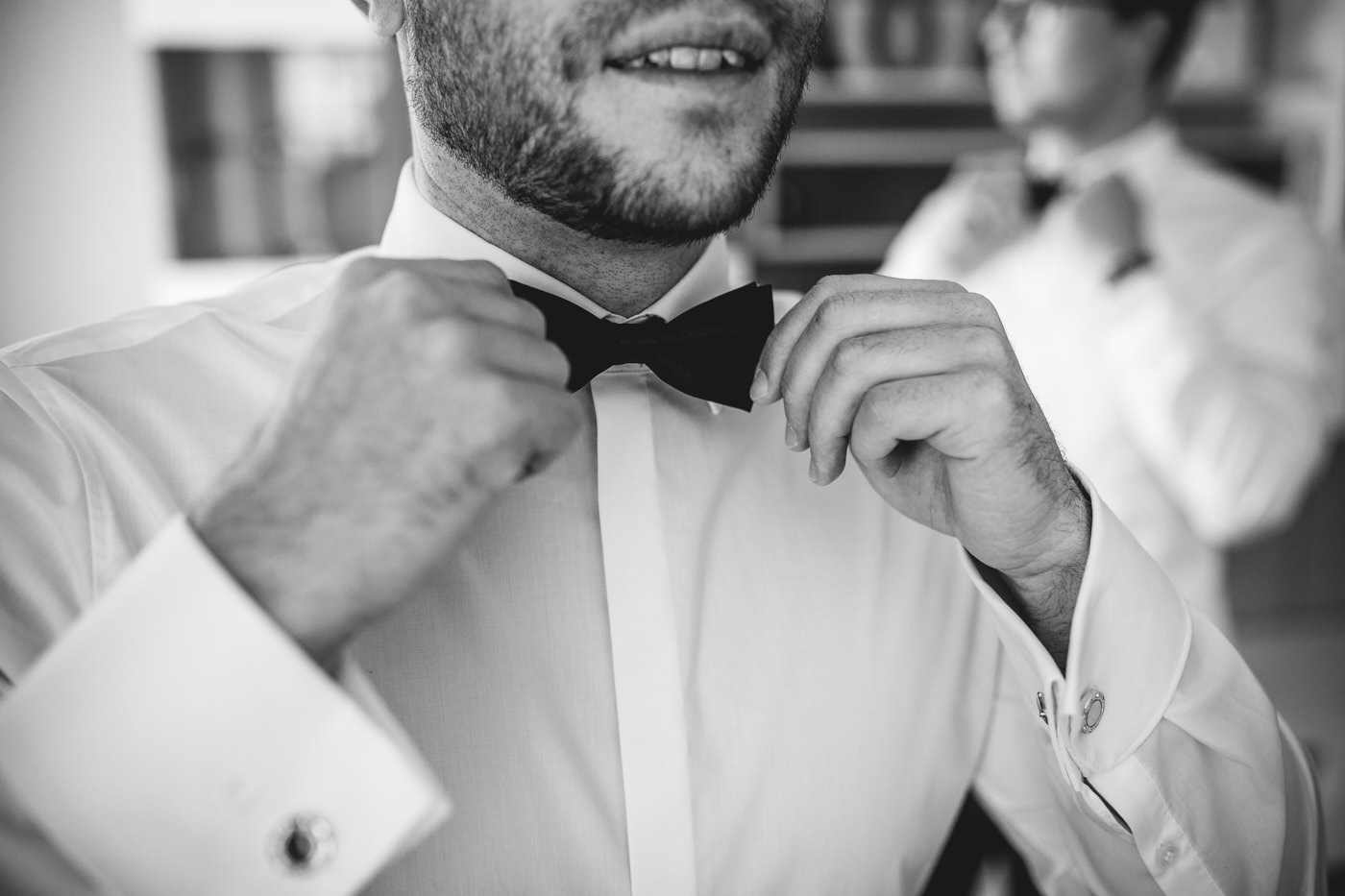 Br&auml;utigam zupft Fliege zurecht. Als Hochzeitsfotograf in Bad Ems.