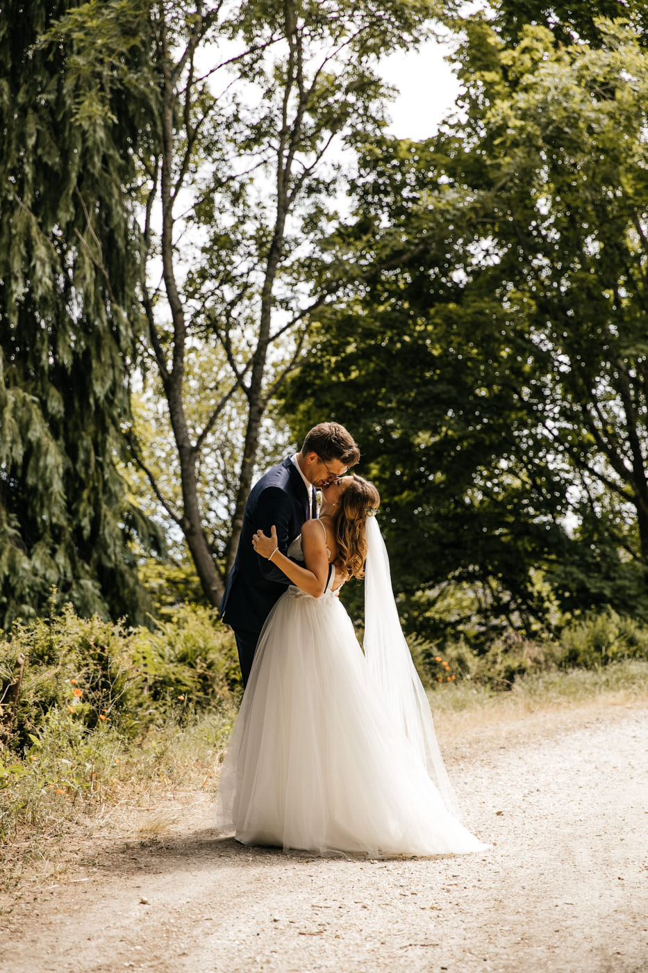Fotoshooting am Hochzeitstag, Brautpaar-Shooting. Brautpaar, k&uuml;sst sich auf dem Waldweg. Hochzeitsfotograf f&uuml;r Koblenz
