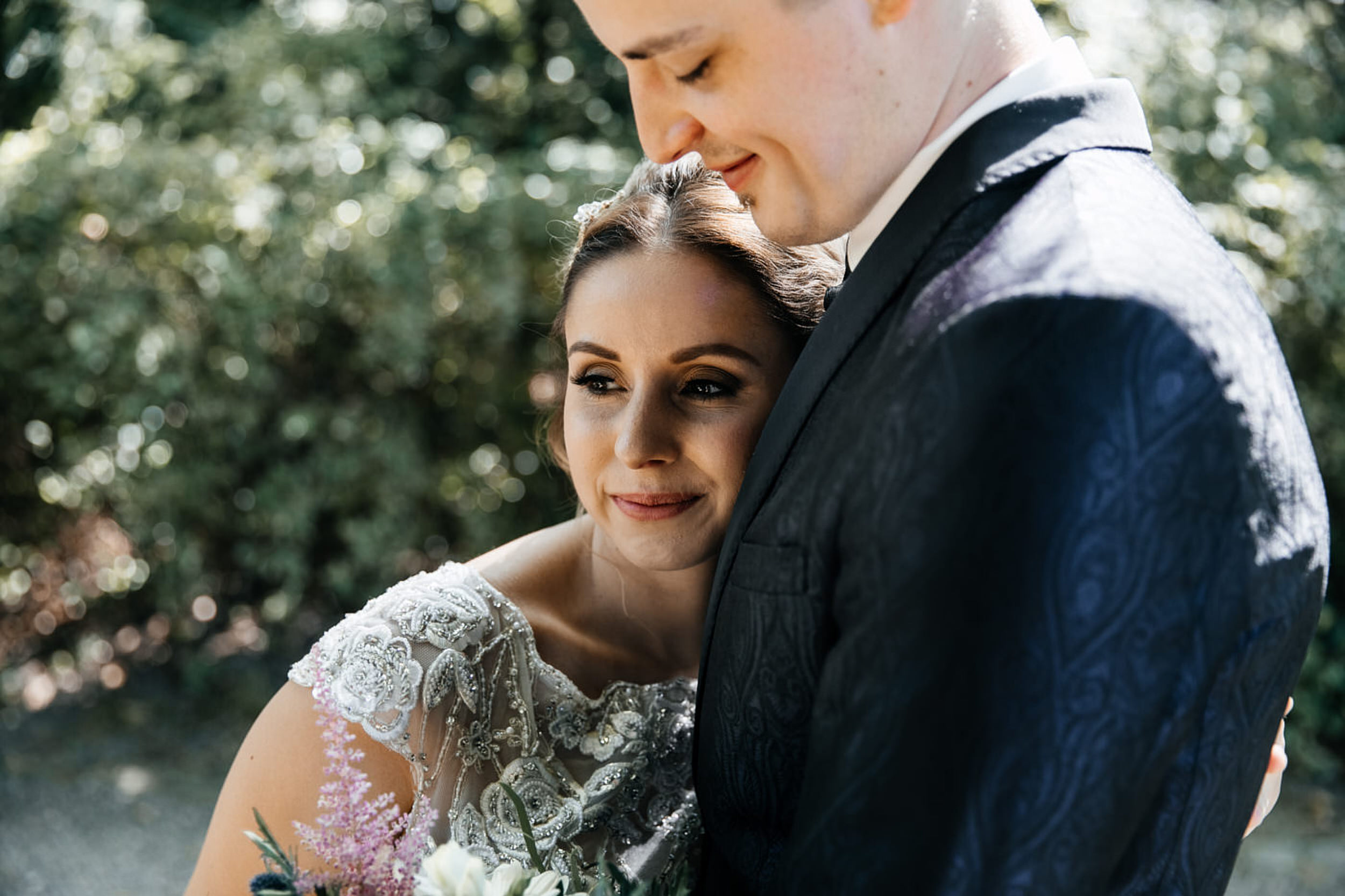 Hochzeitspaar umarmt sich. Fotoshooting im Palaisgarten in Detmold. Begleitung als Hochzeitsfotograf in Detmold. Hochzeitsfotograf in Detmold.