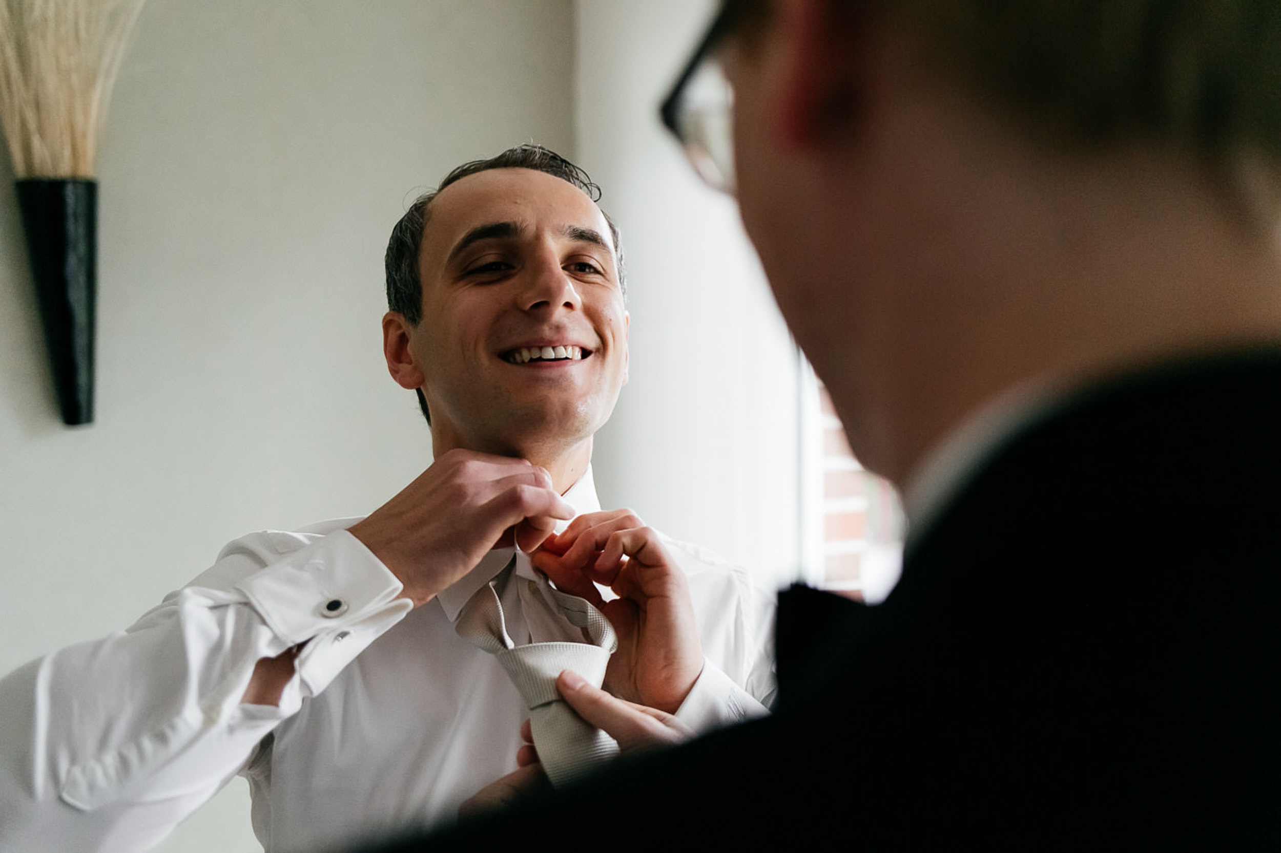 Trauzeuge hilft dem Br&auml;utigam die Krawatte umzu Inden