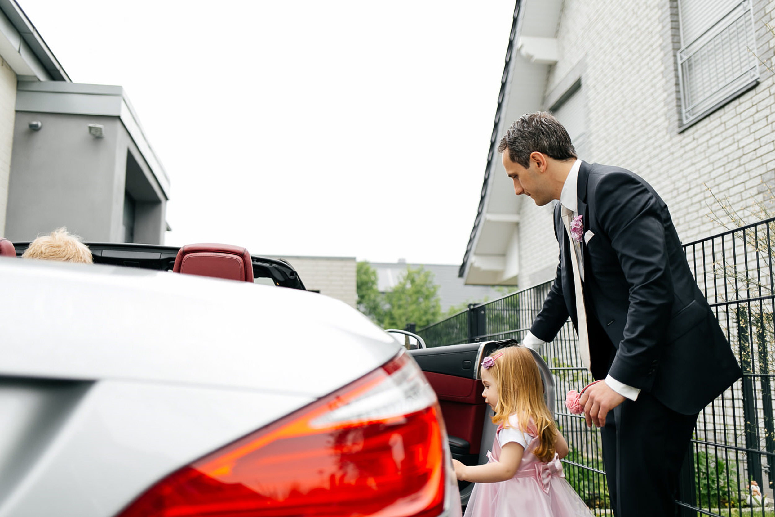 Br&auml;utigam, mach die Auto-T&uuml;r f&uuml;r seine Tochter auf.