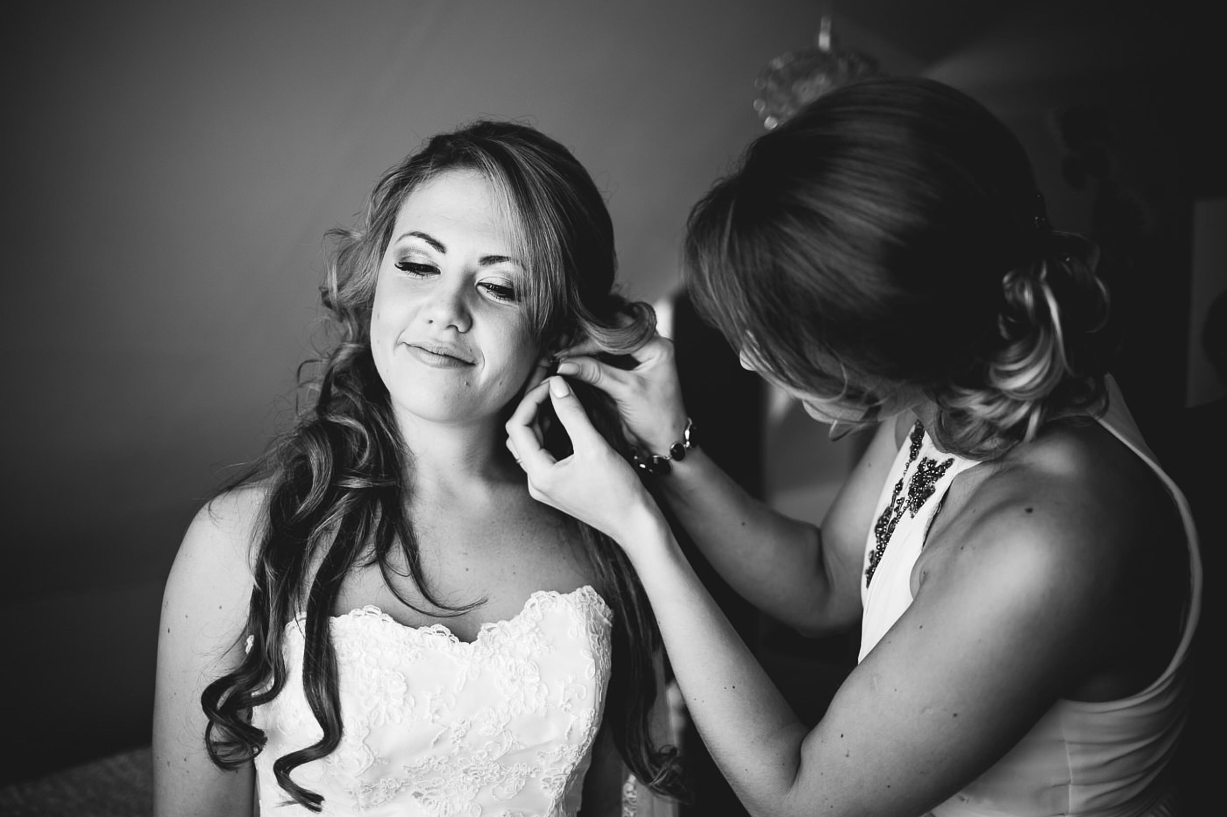 Trauzeugen steckt der Braut die Ohrringe an