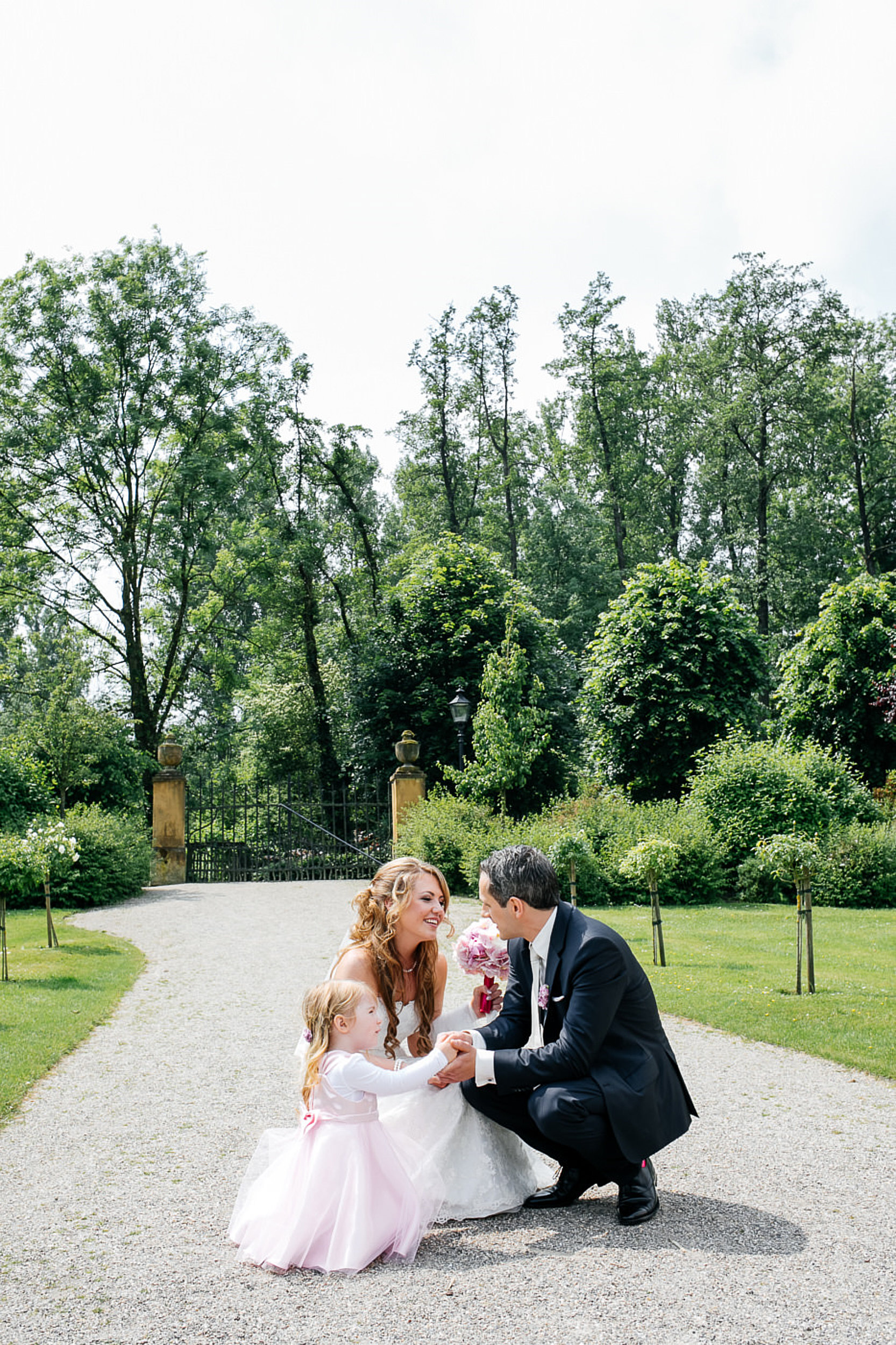 Braut und Br&auml;utigam und die Tochter hocken zusammen.
