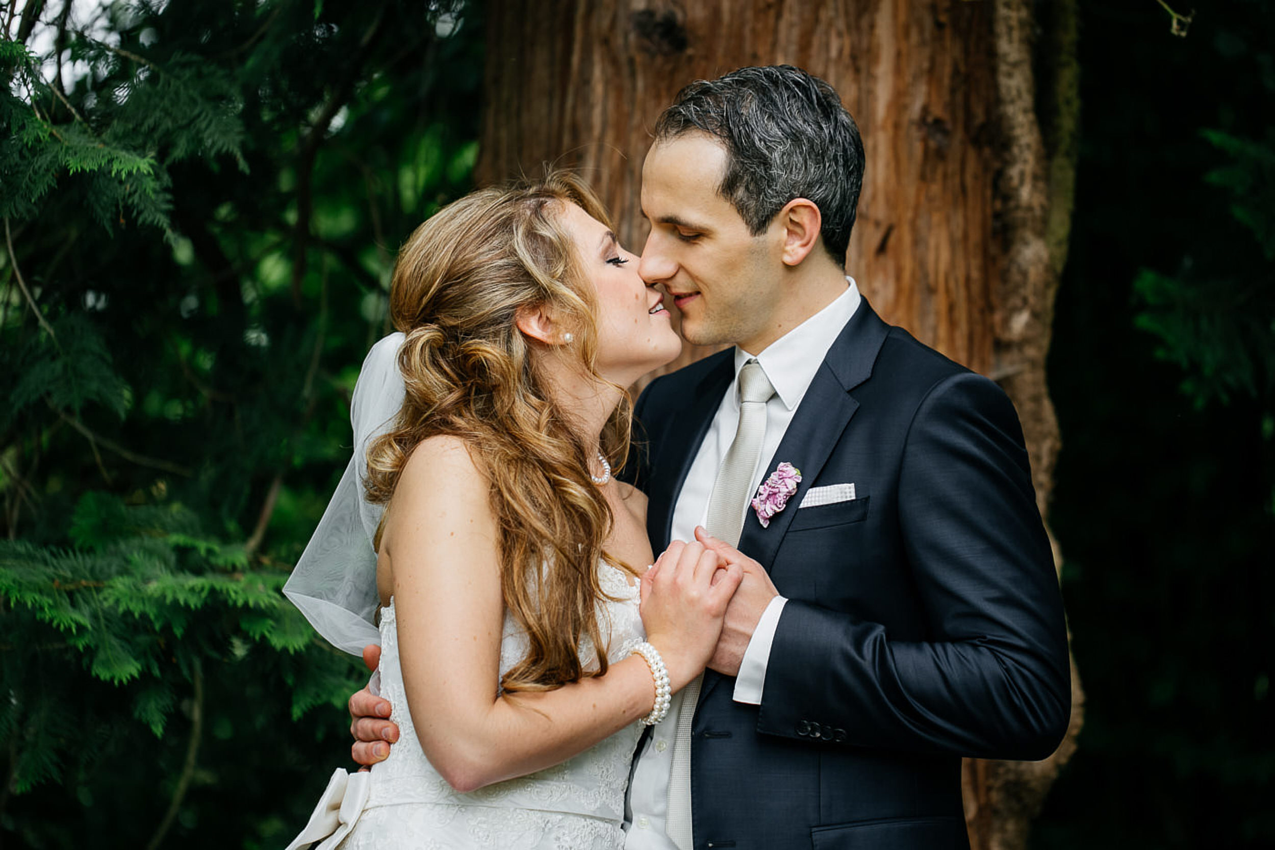 Braut und Br&auml;utigam k&uuml;ssen sich.