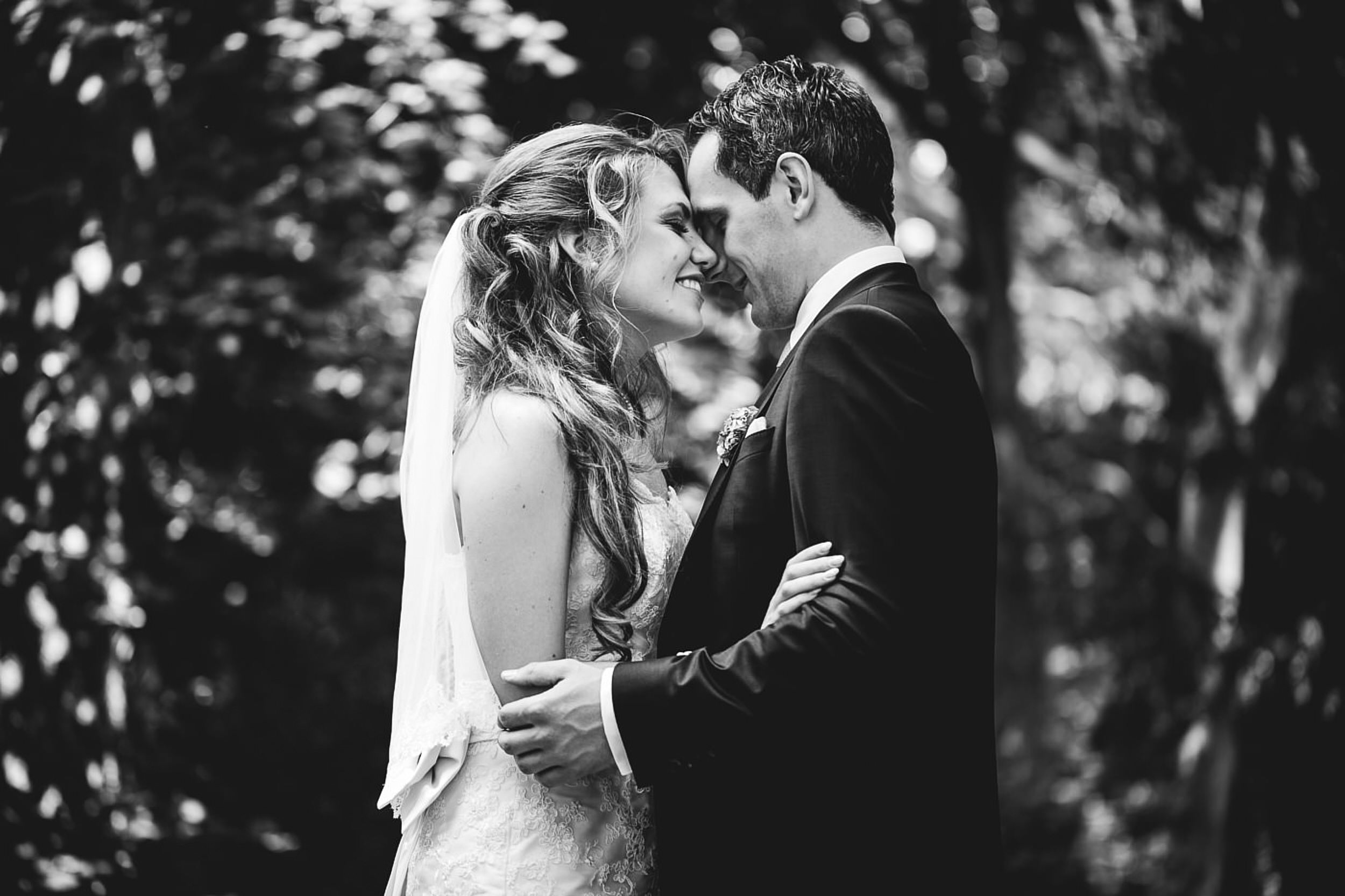 Brautpaar beim Fotoshooting. Stirn an Stirn. Braut l&auml;chelt.