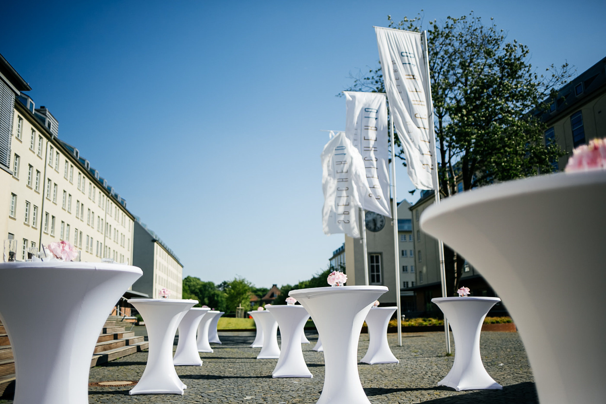 Hochzeitsfotograf f&uuml;r die Hochzeitsfeier. Stehtische drau&szlig;en vor der Hochzeitslocation. Speicher 10