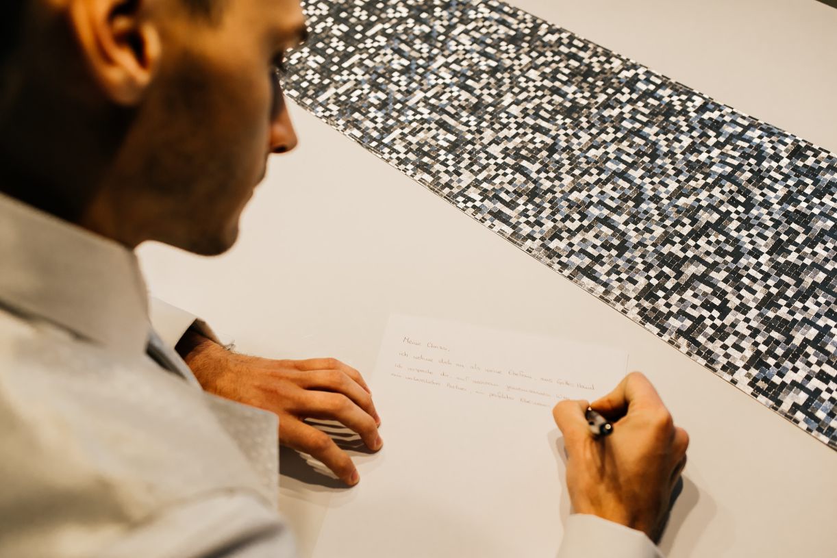 Hochzeitstag. Bräutigam schreibt das Eheversprechen. Hochzeitsfotograf in Schweinfurt.