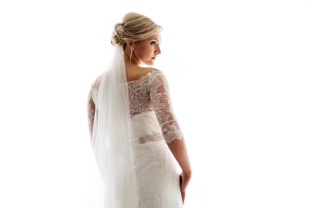 Vorbereitung der Braut. Braut auf dem weißen Hintergrund. Hochzeitsfotograf in Schweinfurt.