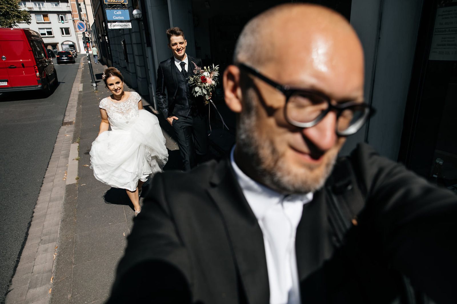Selfie des Fotografen mit Brautpaar auf der Straße – Hochzeitsfotograf Detmold. Hochzeitsfotograf | Hochzeitsvideograf NRW