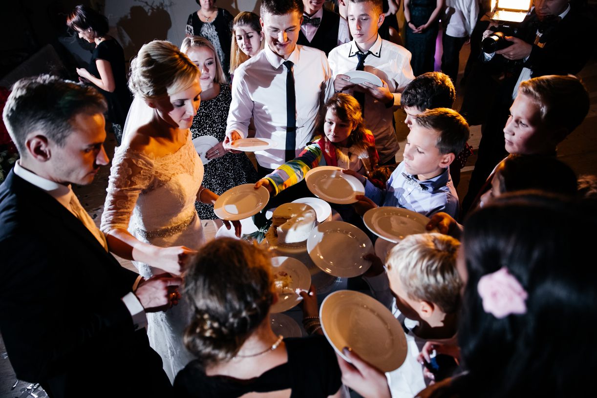 Hochzeitsfeier - Gäste stehen mit den Tellern und warten auf die Hochzeitstorte. Hochzeitsfotograf in Schweinfurt.