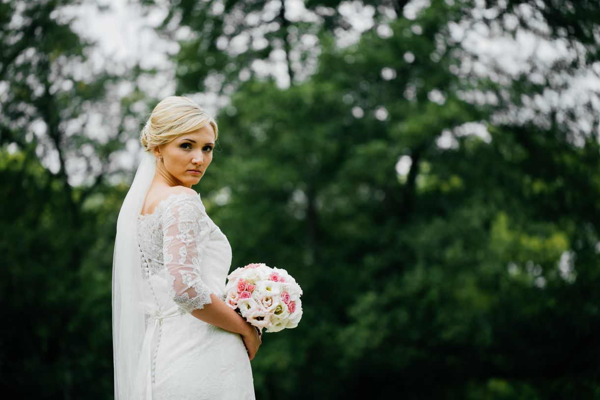 Fotoshootig am Hochzeitstag. Braut mit dem Brautstrauß schaut über die Schulter zur Kamera. Hochzeitsfotograf in Schweinfurt.